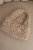 Women's winter hat made of fluffy knit with an elegant button beige