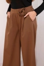 Elegant women's trousers with wide legs and a decorative flower light brown