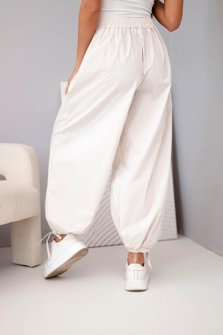 Women's cotton trousers with elastic waistband and tie fastening at the bottom beige