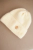 Women's winter fluffy hat with decorative button ecru
