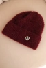 Women's winter fluffy hat with a decorative button burgundy