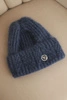 Women's winter hat made of fluffy knit with an elegant button denim