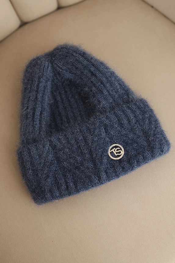 Women's winter hat made of fluffy knit with an elegant button denim