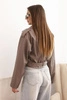 Short women's jacket made of eco-leather with a belt and collar cappuccino