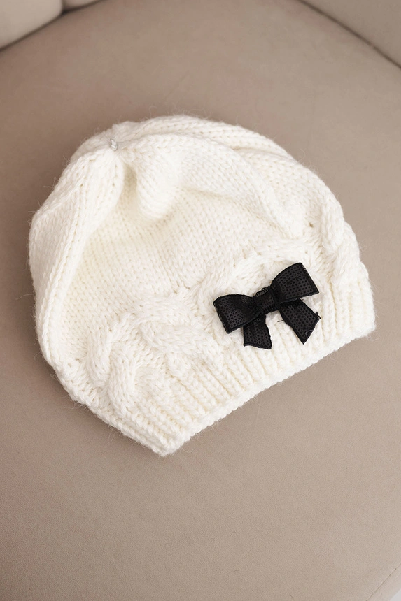 Women's winter hat with a decorative bow and braided pattern K438 ecru