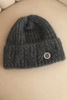 Women's winter hat made of fluffy knit with an elegant button graphite