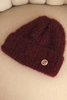 Damenwintermütze aus flauschigem Strick mit elegantem Knopf bordowa